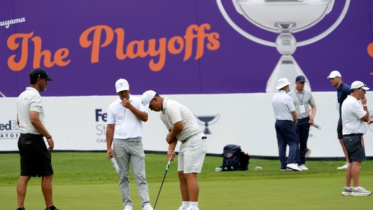 Players work on their game on the practice green at...