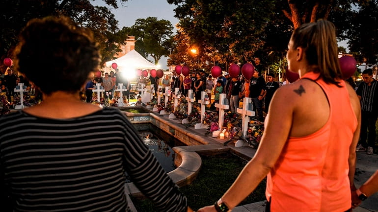 A vigil for the Texas shooting victims at a makeshift memorial in...