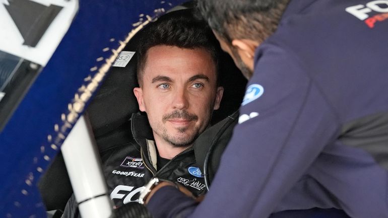 Race car driver and actor Frankie Muniz, left, talks to...