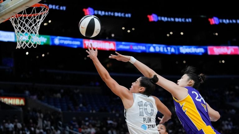 Las Vegas Aces guard Kelsey Plum, left, scores past Los...