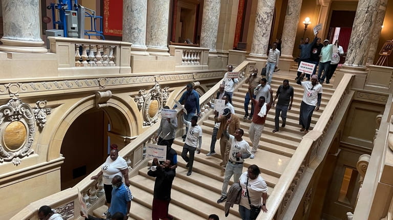 Dozens of protesters descend a staircase in the Minnesota State...