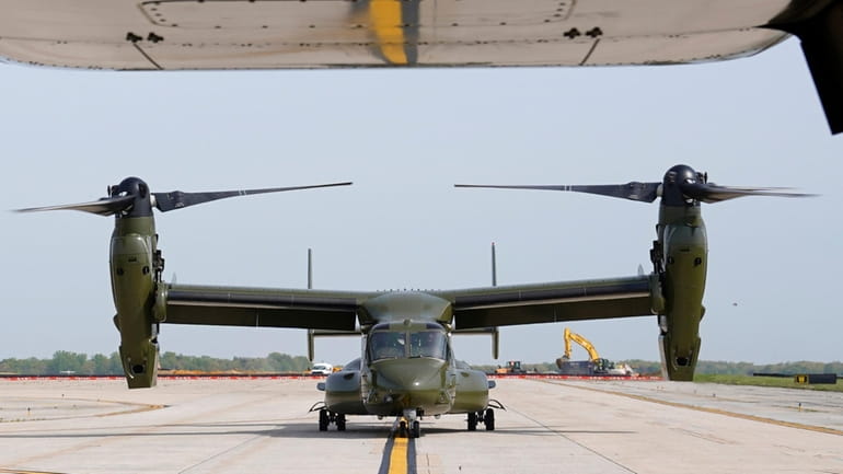 A U.S. Marine Corps Osprey aircraft taxies behind an Osprey...