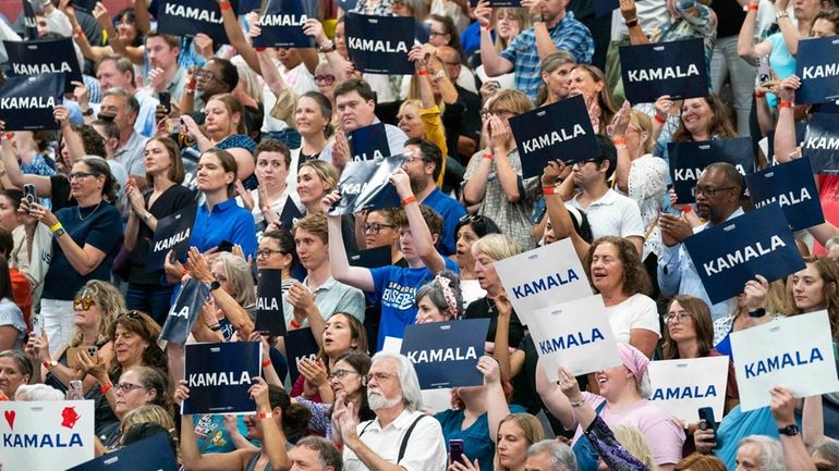 Supports hold up signs in support of Vice President Kamala...