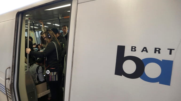 Bay Area Rapid Transit passengers wait for a BART train...