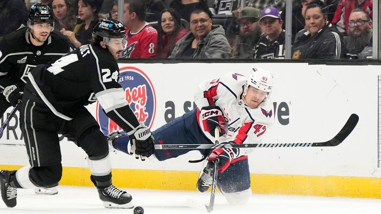 Washington Capitals left wing Beck Malenstyn, right, passes the puck...