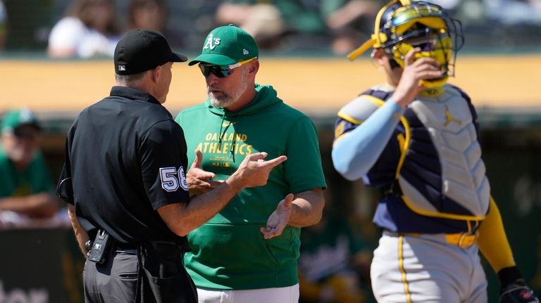 Oakland Athletics manager Mark Kotsay, middle, gestures while talking with...