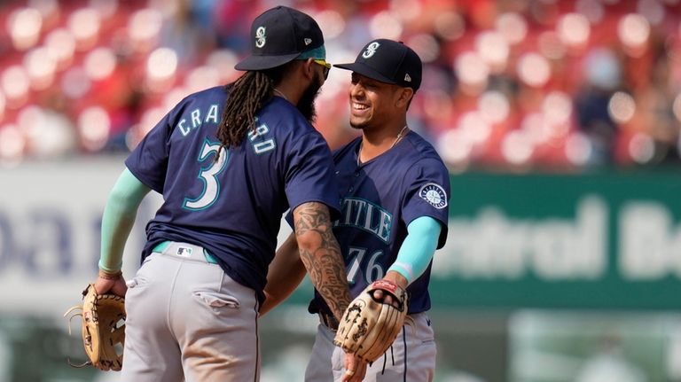 Seattle Mariners' J.P. Crawford (3) and Leo Rivas (76) celebrate...