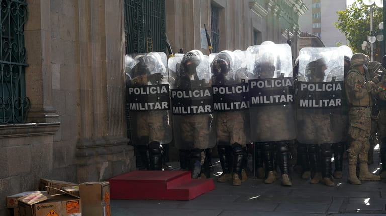 Military police form a phalanx outside the government palace at...