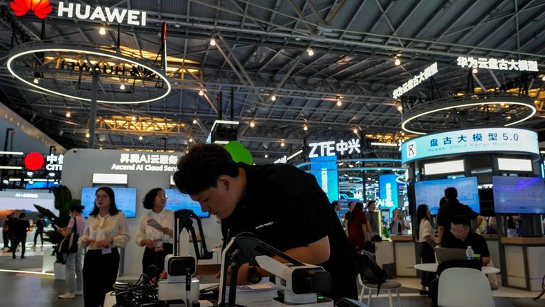 Visitors tour the Huawei and ZTE exhibition booths during the...