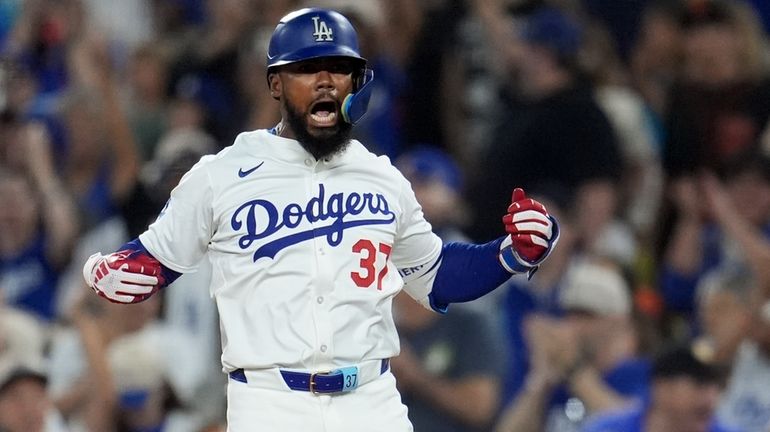 Los Angeles Dodgers' Teoscar Hernández reacts after at first base...