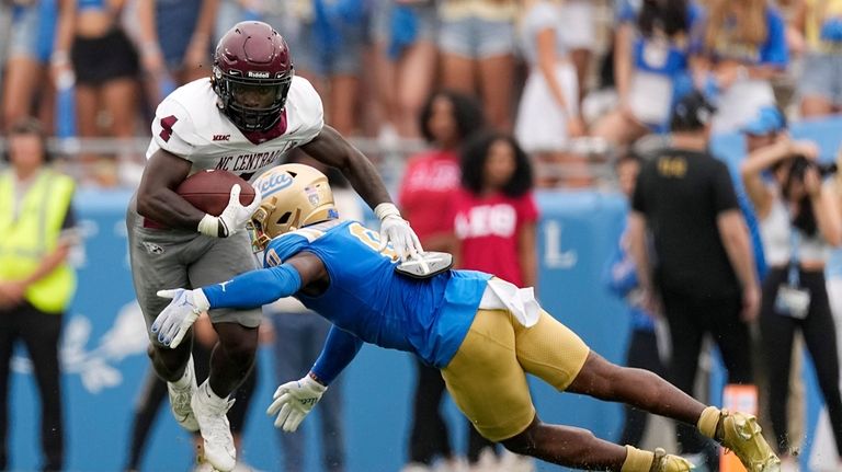 North Carolina Central running back J'Mari Taylor, left, is tackled...