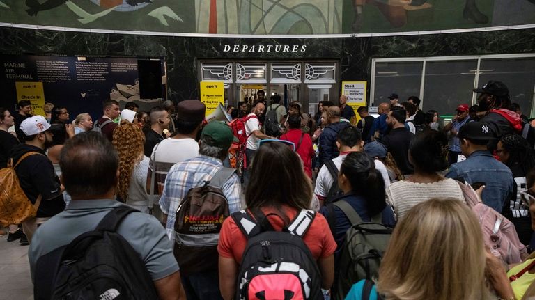 Customers wait in line at a departure area for Spirit...