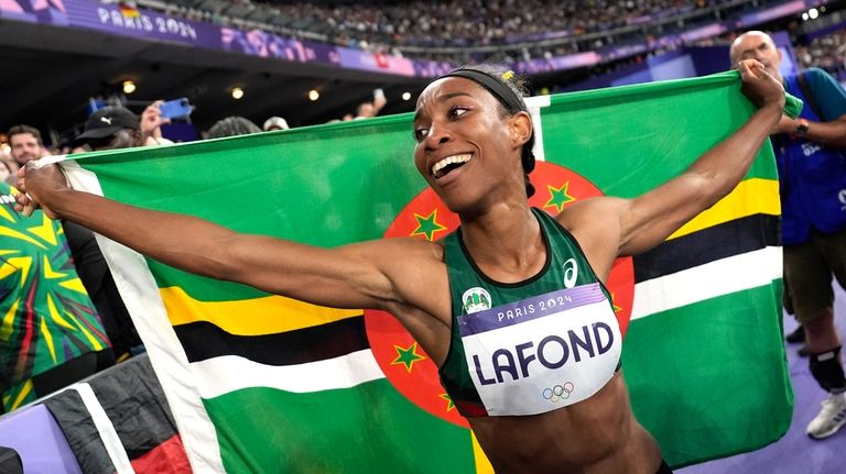 Thea Lafond, of Dominica, celebrates after winning the women's triple...