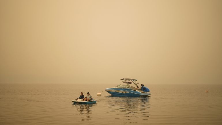 Smoke fills the air as Pat Manzuik and her husband...