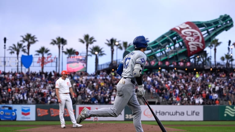 Los Angeles Dodgers' Shohei Ohtani, right, runs the bases after...