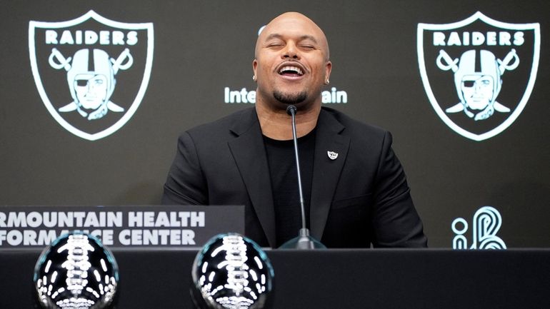 Las Vegas Raiders head coach Antonio Pierce chants at a...