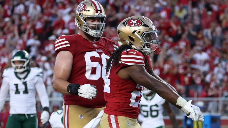 San Francisco 49ers running back Jordan Mason, right, celebrates with...