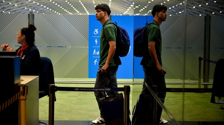 French rugby player Hugo Auradou holds a suitcase at the...