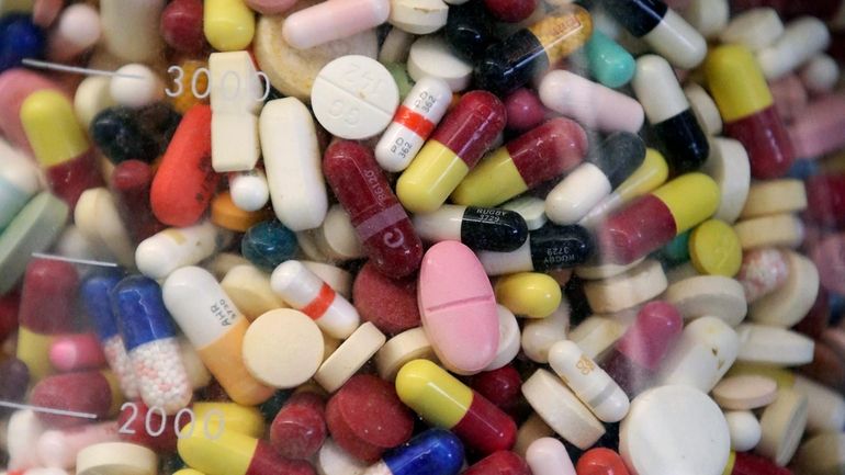 Prescription drugs are seen in a glass flask at a...