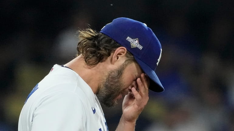 Los Angeles Dodgers starting pitcher Clayton Kershaw rubs his face...