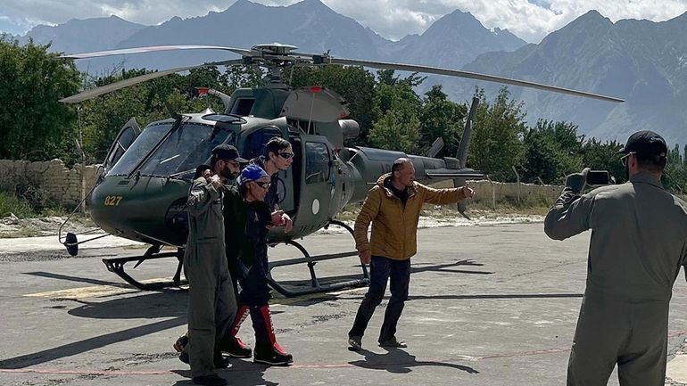 Two Russian climbers, center, who were evacuated from the base...