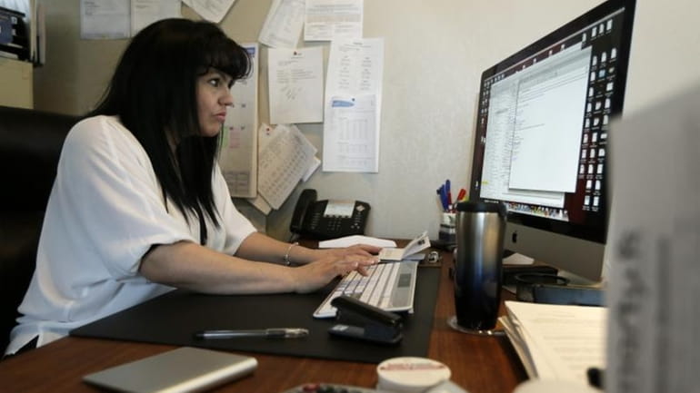 Consuelo Gomez works in her office at facilities management company...
