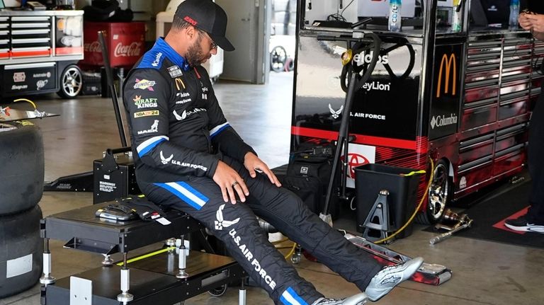 Bubba Wallace sits in his garage before a practice session...