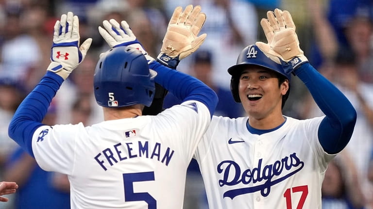 Los Angeles Dodgers' Freddie Freeman, left, is congratulated by Shohei...
