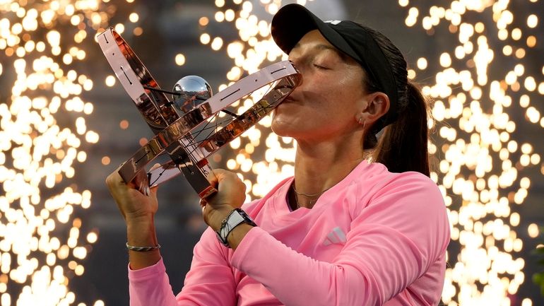 Pyrotechnics fire behind Jessica Pegula, of the United States, as...