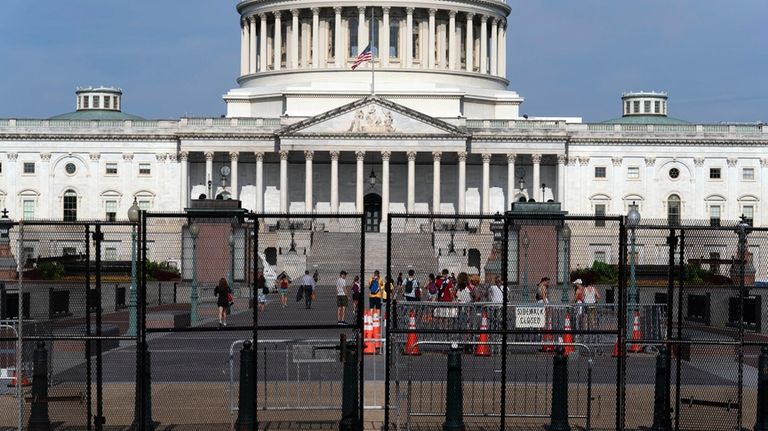 The U.S. Capitol is seen behind a security fence a...