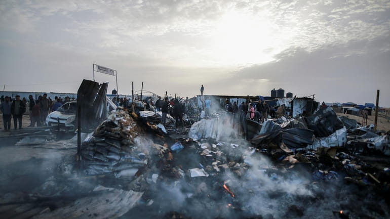 Palestinians look at the destruction after an Israeli strike where...