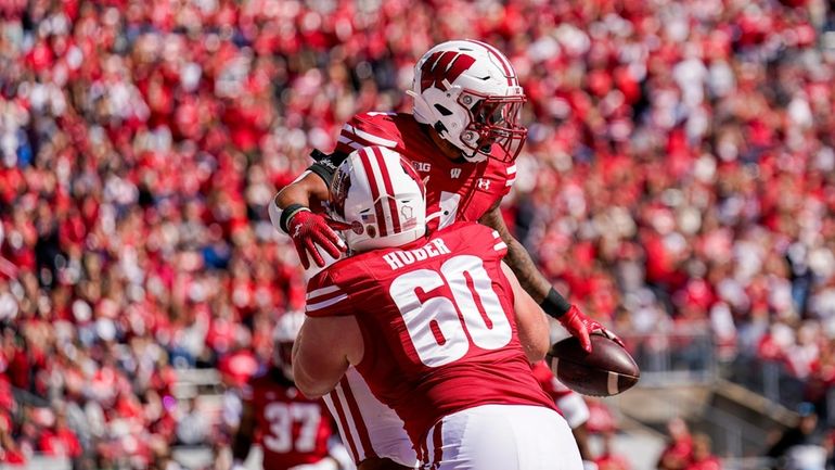 Wisconsin offensive lineman Joe Huber (60) congratulates running back Chez...