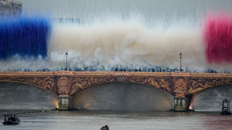 The Olympic torch travels by boat as ceremonial smoke in...