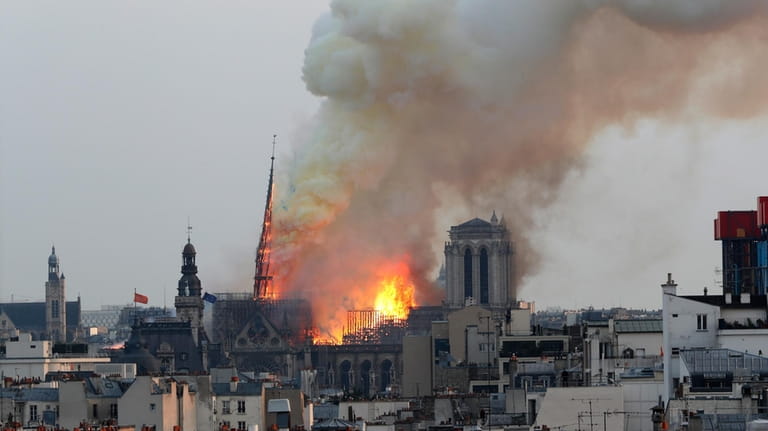 Flames rise from Notre Dame cathedral as it burns in...