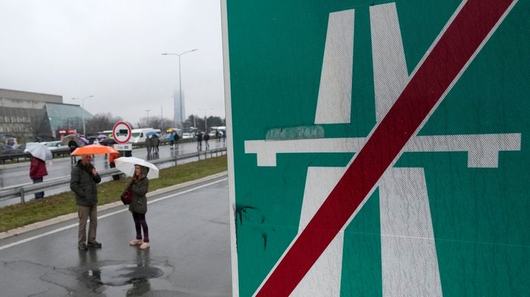 Serbian protesters opposed to lithium mining stand on the highway...