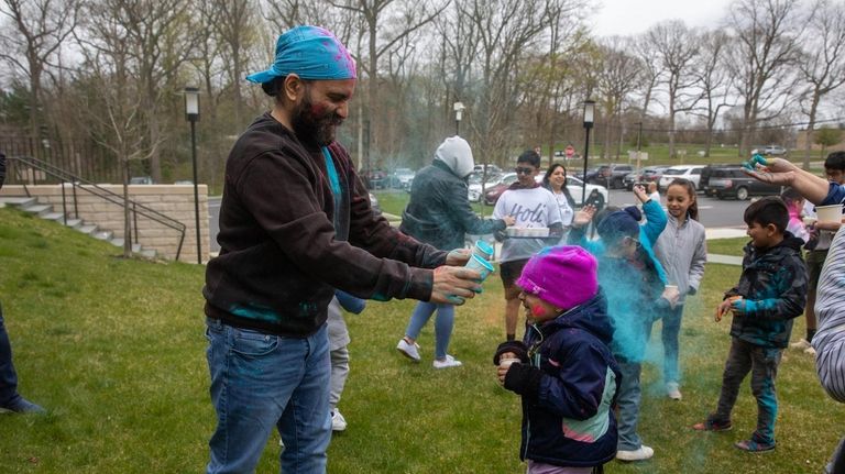 Jaideep Oberoi, left, throws color on his daughter Sahiba Oberoi,...