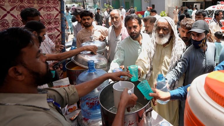 Volunteers provide lime sugar water to people at a camp...