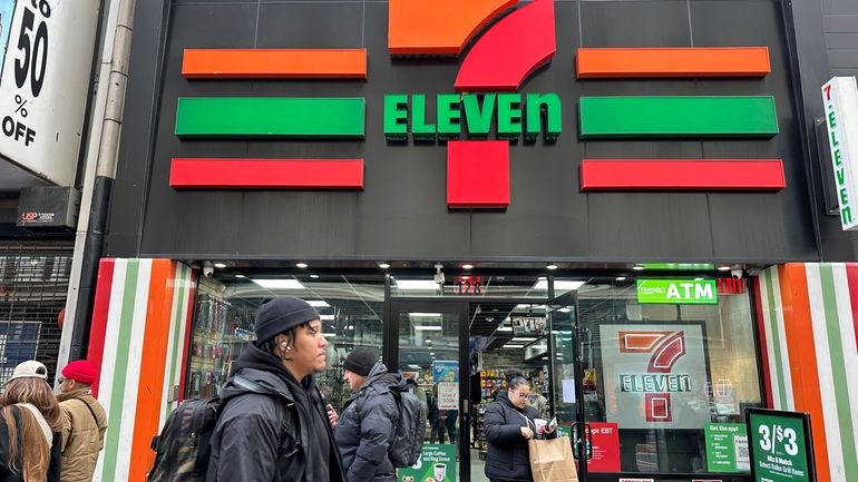 People shop at a 7-Eleven convenience store in New York,...