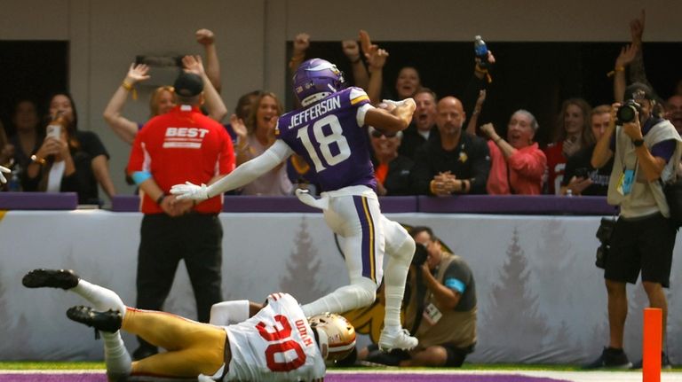 Minnesota Vikings wide receiver Justin Jefferson (18) scores on a...