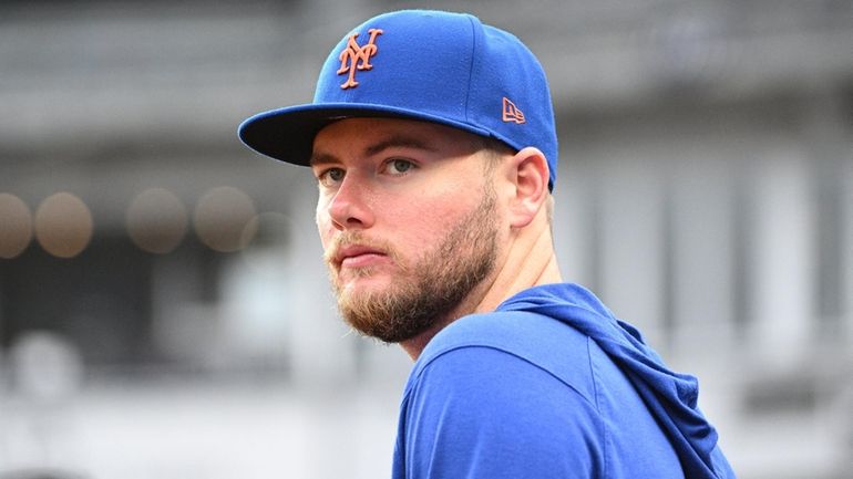 Mets pitcher Christian Scott looks on from the dugout before...