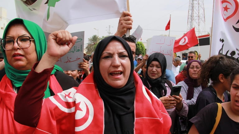 Tunisians take part in a protest against the presence of...