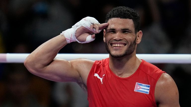 Cuba's Erislandy Alvarez, celebrates after defeating Thailand's Bunjong Sinsiri in...