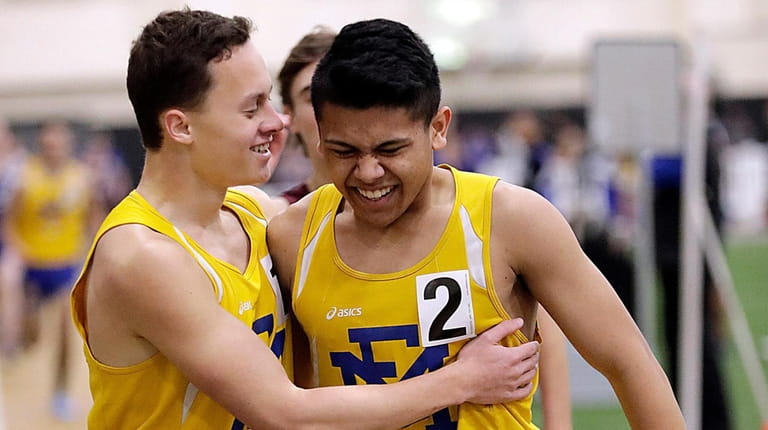 East Meadow's Jeremy Erman (l) congratulates teammate John Meah (2))...