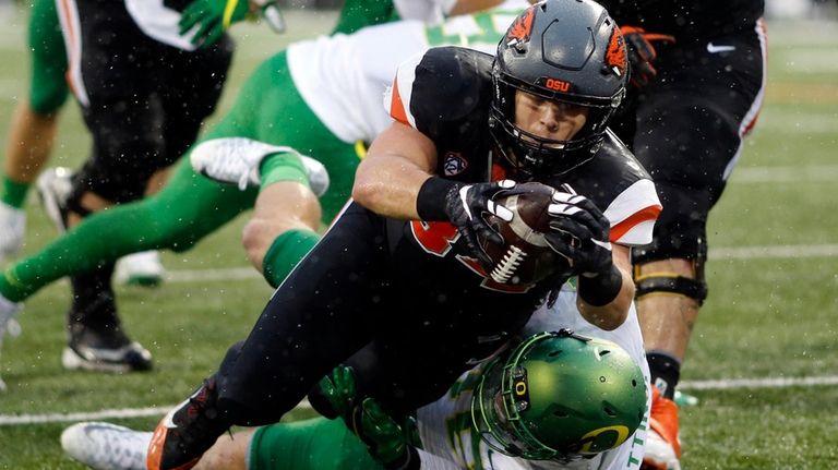 Oregon State running back Ryan Nall, top, dives over Oregon's...