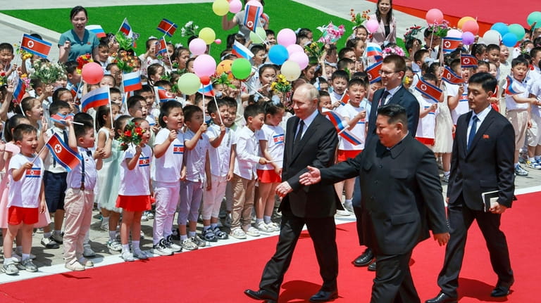 Russian President Vladimir Putin, left, and North Korea's leader Kim...