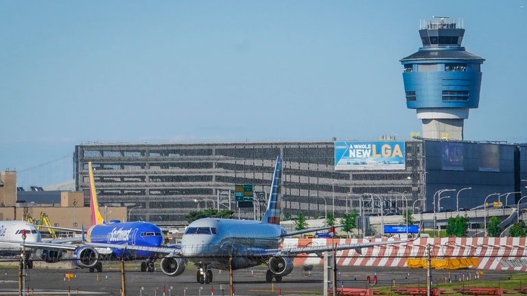 LaGuardia Airport's air traffic control tower, right, is shown as...