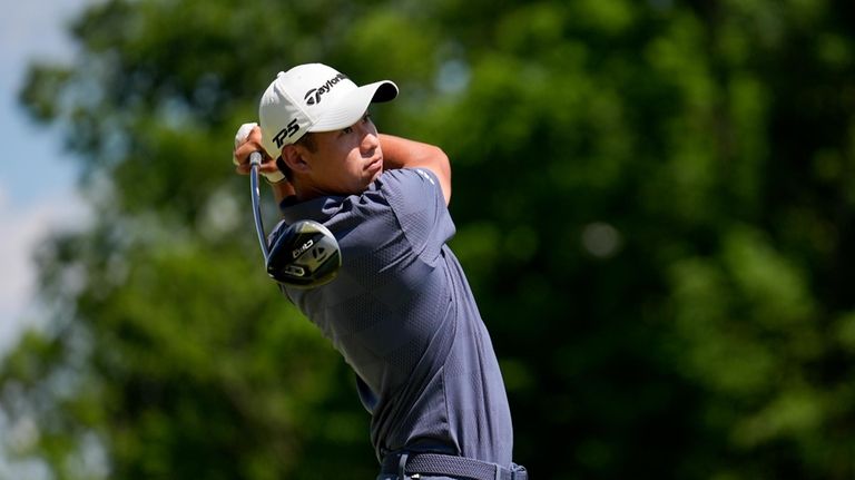 Collin Morikawa watches his tee shot on the fifth hole...