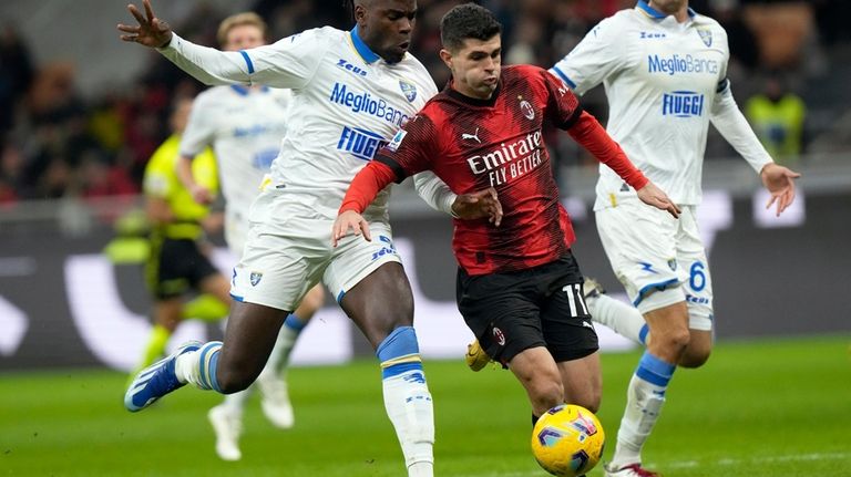 AC Milan's Christian Pulisic, center, runs with the ball to...