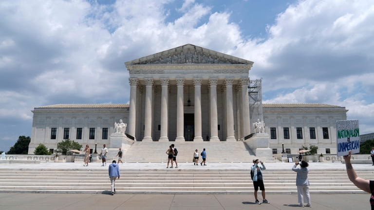 Visitors pose for photographs outside the U.S. Supreme Court Tuesday,...