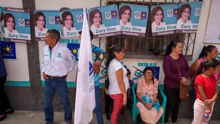 Residents wait for the start of a campaign rally promoting...